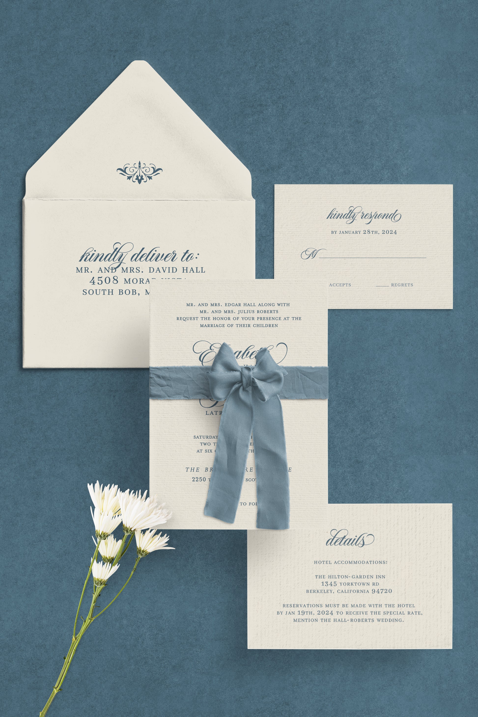Wedding invitation set with envelope, card, and RSVP card on a blue background