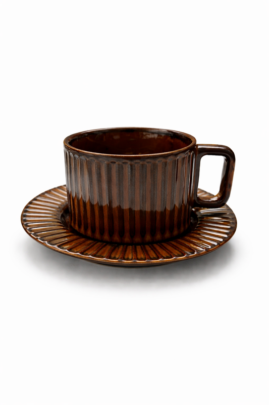 Brown ceramic cup and saucer on a white background